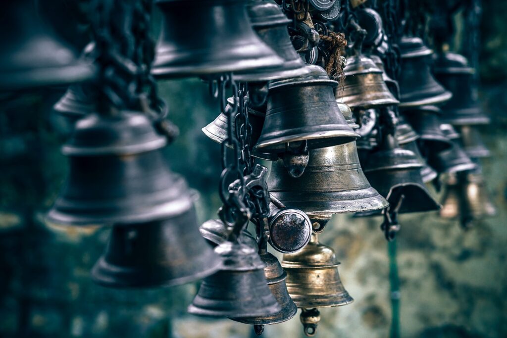 Mehrere Glocken, die mit Ketten miteinander verbunden sind aus Metall (Messing oder Gusseisen)
