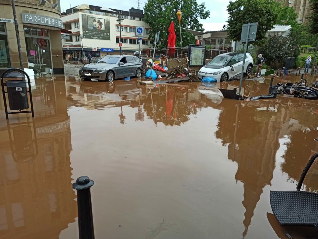 Überflutete Straße mit angespülten Autos